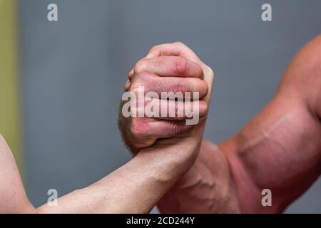 Close-up shot of strong mans' muscles during an arm-wrestling fight