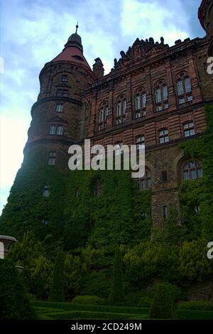 A stunning old castle front with a vast quantity of vines growing on it Stock Photo