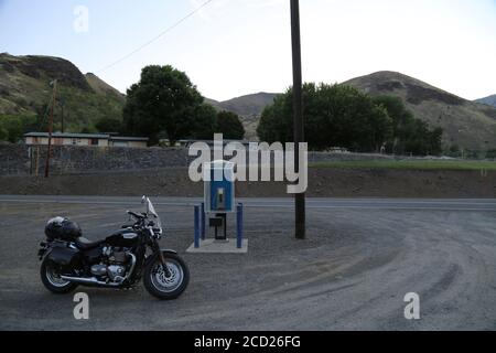 Triumph Speedmaster motorcycle in front of an old public pay phone booth Stock Photo