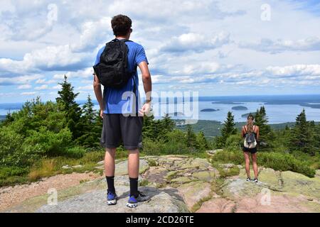 Young man taking photo with his cell phone at the top of a mountain Stock Photo