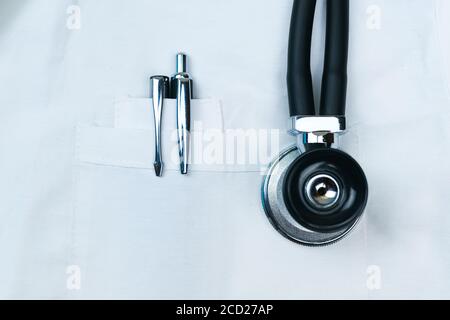 Black pens in the front pocket of the doctor's white coat with Stethoscope phonendoscope close up. Stock Photo
