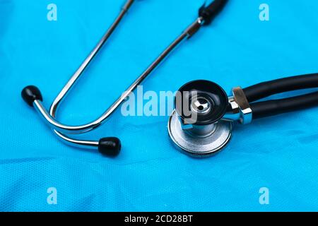 Black Stethoscope and phonendoscope on the blue nonwoven fabric. Selective focus. Medical concept.  Stock Photo