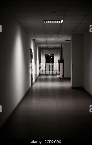 empty long corridor stretching into the future. The concept of holidays, quarantine, evacuation in the office building. Stock Photo