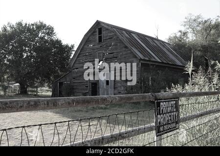 A old wooden barn sits decaying in a Oklahoma field after enduring decades of heat, humidity, ice, rain and snow. Stock Photo