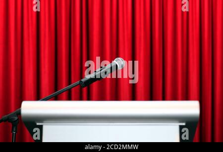 microphone on stage with red curtain background Stock Photo