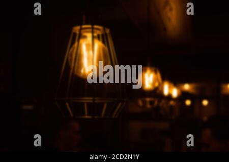 Abstract blur of pendant burning lights for interior decoration shine in the dark. Stock Photo