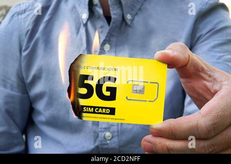 A paranoid man burns a 5G SIM card for fear of harmful radiation. Fighting high-speed Internet 5 g. Destruction of 5P tower technologies. Retrograde r Stock Photo