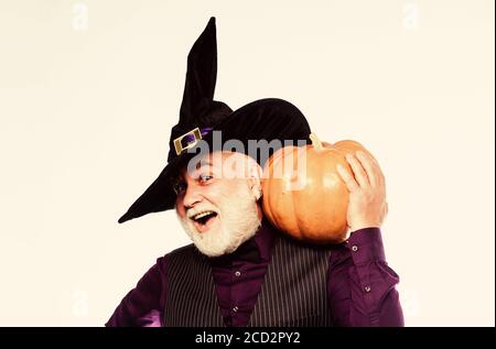 Magic concept. Experienced and wise. Halloween tradition. Cosplay outfit. Senior man white beard celebrate Halloween with pumpkin. Wizard costume hat Halloween party. Magician witcher old man. Stock Photo