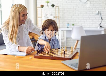 Mom and son play chess in the room. Educational games for children Stock Photo