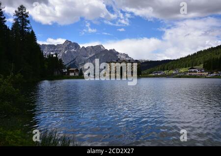 Summer on Lake Misurina, even on a cloudy day the blue of the sky is reflected in the waters of the lake Stock Photo
