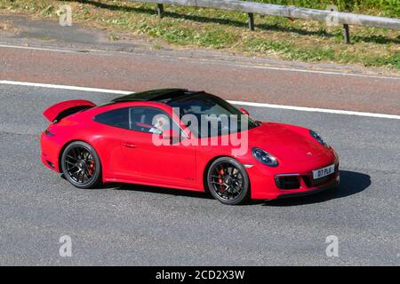 2018 red Porsche 911 Carrera GTS S-A; Vehicular traffic moving vehicles, cars driving vehicle on UK roads, motors, motoring on the M6 motorway highway network. Stock Photo