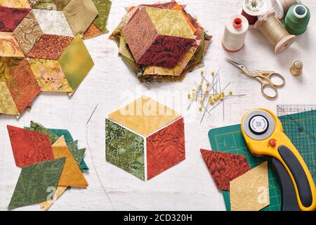 Fragment of tumbling blocks quilt, accessories for quilting on a white surface Stock Photo