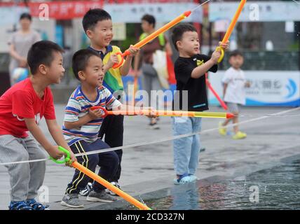 Children play water around the fountain to spare leisure time in summer as Xiaoshu, 11th solar term of the year is coming and the weather is getting h Stock Photo