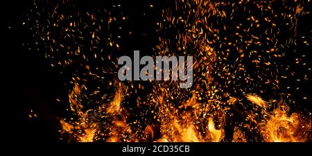 Fire sparks particles with flames isolated on black background. Stock Photo