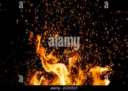 Fire sparks particles with flames isolated on black background. Stock Photo