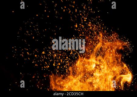 Fire sparks particles with flames isolated on black background. Stock Photo