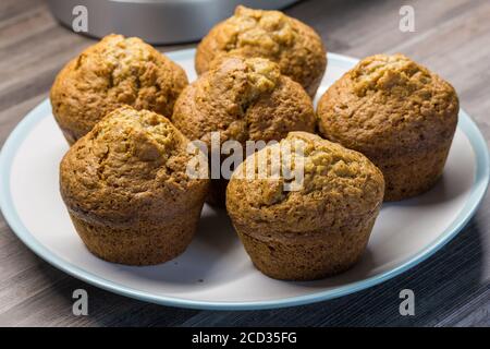 Muffins in plate on kitchen counter top - delicious baked cinnamon and apple cup cakes Stock Photo