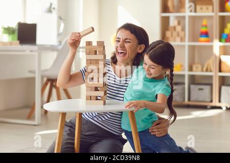 Mother and daughter play board games at home. Happy family. Stock Photo