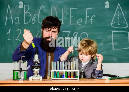 Powering Whats Next. small boy with teacher man. son and father at school. Modern Laboratory. Back to school. Biologist Conducts Experiments by Synthesising Compounds. Stock Photo