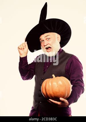 Cosplay outfit. Senior man white beard celebrate Halloween with pumpkin. Wizard costume hat Halloween party. Magician witcher old man. Magic concept. Experienced and wise. Halloween tradition. Stock Photo