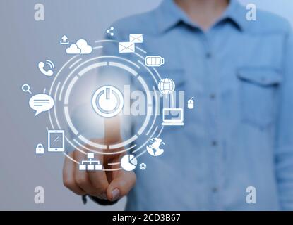 IoT. Woman pressing start button on digital screen with communication network icons Stock Photo