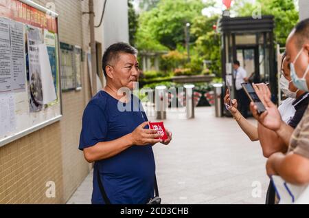 53-year-old Chinese man Liang Shi steps out of the testing center, where he just finished his 24nd Gaokao, also known as the 2020 National College Ent Stock Photo