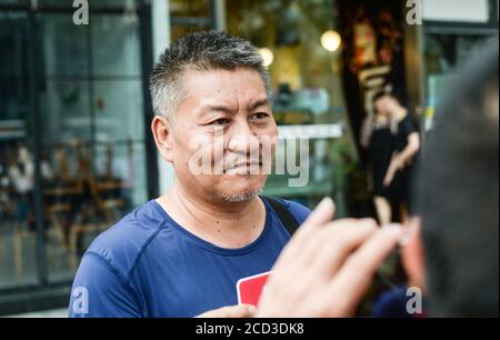 53-year-old Chinese man Liang Shi steps out of the testing center, where he just finished his 24nd Gaokao, also known as the 2020 National College Ent Stock Photo