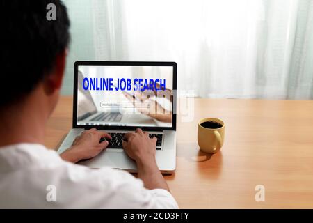 Business and job concept. Man use laptop computer online website find new career. Man searching vacancies or position on the internet. Man unemployed Stock Photo