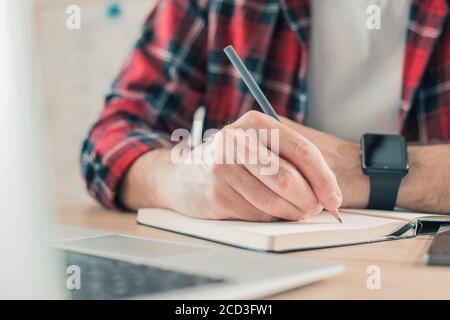 Freelancer writing notes in notebook, selective focus Stock Photo