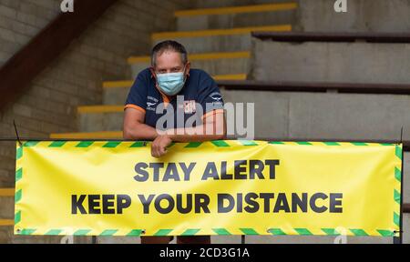 Farmer at a livestock auction market wearing a face mask during the Covid-19 pandemic in the UK. Looking at camera Stock Photo