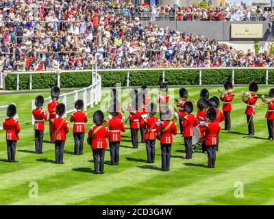 Guardmen in red uniforms play in the Parade Ring and entertain the crowd during Royal Ascot, Ascot Racecourse, Ascot Berkshire Stock Photo