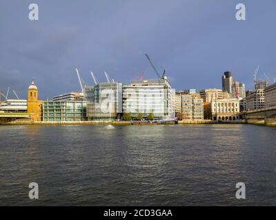 View of modern office developments and Fishmongers Hall on the River Thames north bank between London and Cannon Street rail bridges, City of London Stock Photo