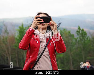 young woman takes a selfie on a background of mountains Stock Photo