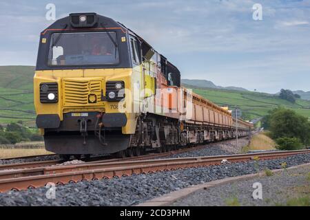 Colas Railfreight class 70 locomotive at  Helwith Bridge on the Settle to Carlisle Railway with a freight train carrying bulk railway ballast Stock Photo