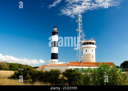 Lighthouse with blue sky and summer clouds and terracotta roof top in chassiron, Oleron Island, France Stock Photo