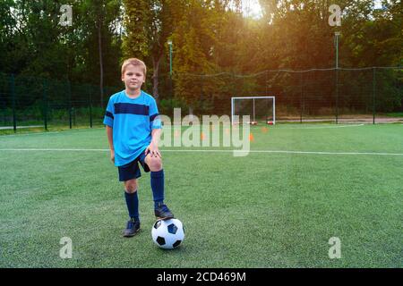 Full length portrait of a kid in sportswear posing with a soccer ball outdoors Stock Photo