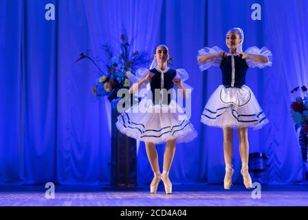 Young girls ballerina in a blue and white costume dancing ballet performance on stage in a theater Stock Photo