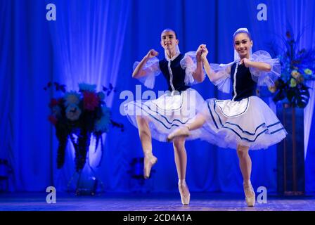 Young girls ballerina in a blue and white costume dancing ballet performance on stage in a theater Stock Photo