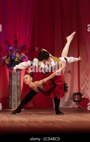 Duet young girl ballerina and a young man dancing ballet performance on stage in a theater Stock Photo