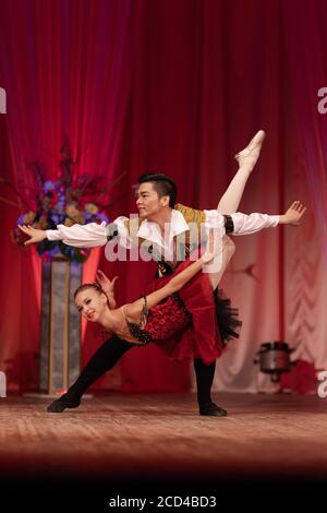 Duet young girl ballerina and a young man dancing ballet performance on stage in a theater Stock Photo