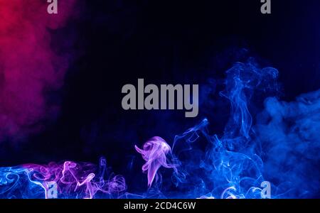 Conceptual image of multi-colored smoke isolated on dark black background, Halloween design element. Stock Photo