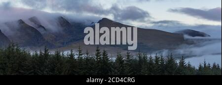 Panorama of dramatic clouds and morning mist moving over scenic landscape on the dingle peninsula at dawn, wild Atlantic way in county Kerry, Ireland Stock Photo