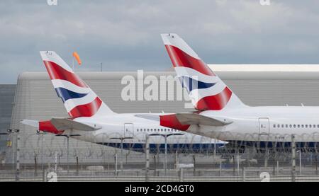Heathrow Airport, London, UK. 26 August 2020. Sunlit tailfin on British Airways Boeing 777 aircraft G-VIIJ and G-VIIN parked at Heathrow Airport since 21st and 23rd August. COVID-19 pandemic has seen the airline industry slump worldwide, with approx 11% of passengers at Heathrow in July 2020 compared with the same month in 2019, and approx 25% of air traffic movements at Heathrow in July 2020 compared with July 2019. Credit: Malcolm Park/Alamy Stock Photo