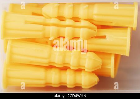 Yellow plastic dowels for self-tapping screws close-up. Stock Photo
