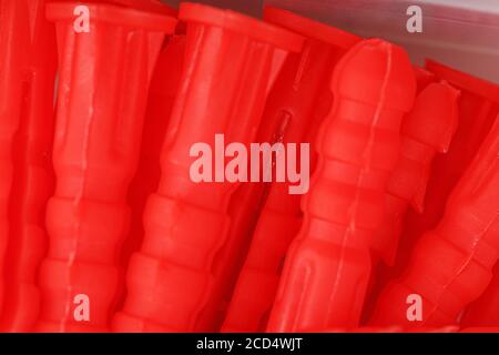 Red plastic dowels for self-tapping screws close-up. Stock Photo