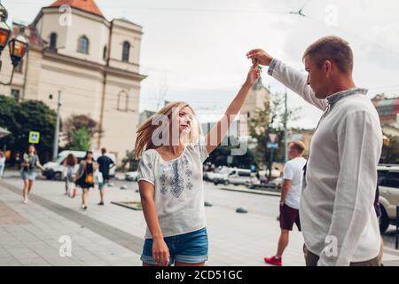 Young people in love walk in old Lviv city wearing traditional ukrainian shirts. Couple dances having fun Stock Photo