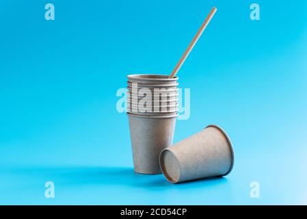 Stack of disposable paper cups on blue background. Eco-friendly tableware. Recycling concept. Zero waste theme. Copy space Stock Photo
