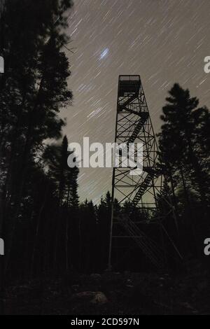 Star trails over the observation tower on Trout Mountain, ME. Stock Photo