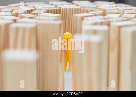 A human figure stands in the middle of high walls. Concept photo how high blockades limit the human being. Figure cries. Stock Photo