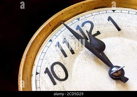 Old vintage clock shows 2 minutes to 12 o'clock against a black background. New year's eve or countdown concept. Stock Photo